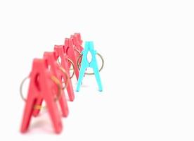 Different or competition concept using colorful plastic clothespins over white background photo