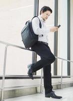 Business traveler using mobile phone during his journey at airport terminal photo