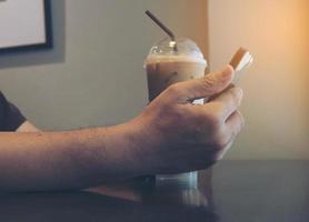 Man is using mobile phone while sitting in coffee shop photo