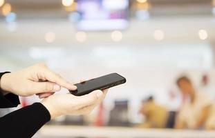 A man is using telephone over colorful blurred bokeh light in office and people background photo