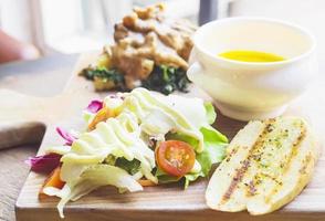 Roasted chicken served with salad and garlic bread photo