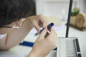 hombre haciendo un informe usando una máquina de encuadernación de peine - personas que trabajan con el concepto de herramientas estacionarias foto