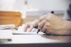 Businessman holding pen while working with document - business people working concept photo