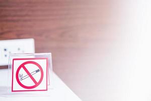 No smoking sign with wooden wall texture background and white light shining from right side photo