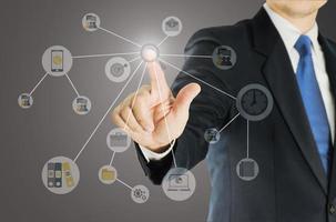 Businessman pointing out with business icons overlay photo