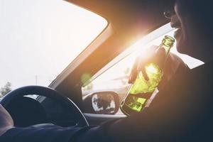 Man drinking beer while driving a car photo