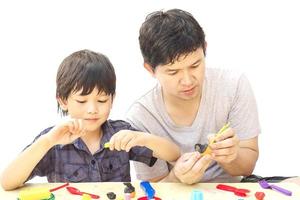 Father is playing Halloween clay with his son over white background photo