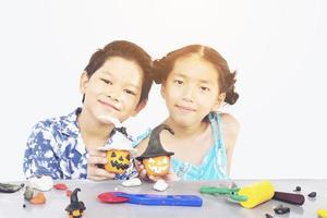 niño y niña juegan felizmente a un juguete de arcilla foto