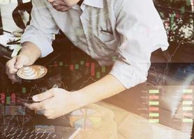 Businessman is working with his computer in coffee shop with stock chart and data overlay photo