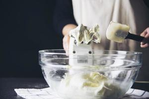 Lady making cake putting cream using spatula - homemade bakery cooking concept photo