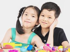 los niños asiáticos están jugando coloridos juguetes de arcilla foto