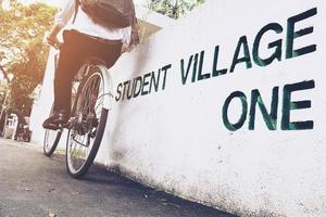 Student is riding bicycle in village green campus photo