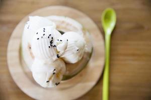 Coconut ice cream serving in fresh coconut shell on wooden table - tasty famous sweet dessert photo