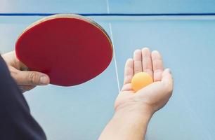 un hombre juega tenis de mesa listo para servir foto