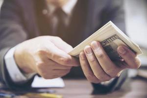 Bank teller man's hands giving dollar banknotes photo