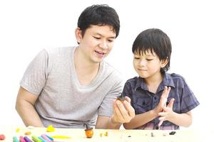 Father is playing Halloween clay with his son over white background photo