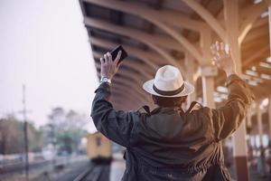 Travel man is waiting train at train station, Chiangmai Thailand, 23 May 2019 photo