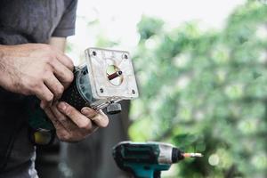 hombre que prepara la máquina herramienta cortadora de laminado del enrutador eléctrico - concepto de taller de carpintería foto