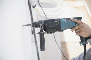Man is installing wall compressor of air conditioner during hot season photo