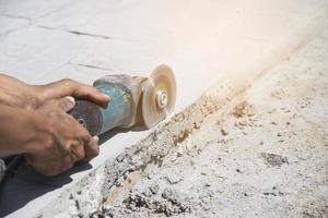 hombre haciendo pisos de concreto o acabado de caminos usando una máquina de pulir a mano foto