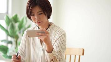 una mujer estudiando en un teléfono inteligente video