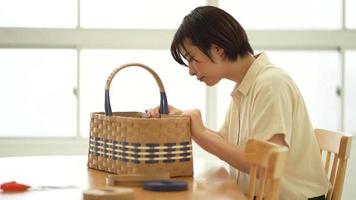 A woman making a basket with a craft band