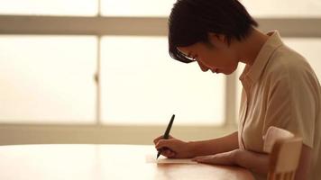 una mujer escribiendo una carta con un pincel video