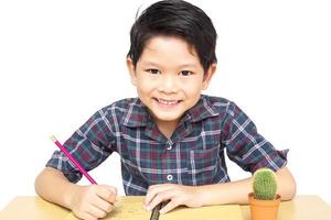 A boy is happily doing homework isolated on white background photo