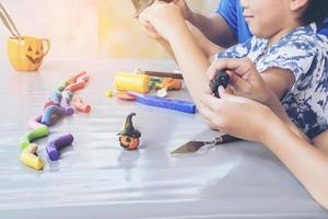 Father is playing clay toy with kid photo