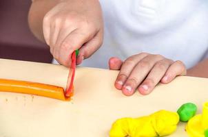 manos de un niño jugando arcilla foto