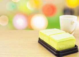 Coffee and cream cake on wooden table with colorful bokeh background photo