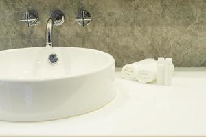 Bath room sink with white cleaning set in a hotel photo