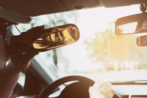 Man drinking beer while driving a car photo