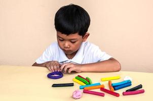 un niño está jugando arcilla de colores foto