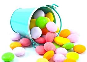 Bucket of colorful candy on white background photo