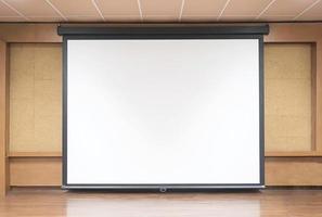 Front view of lecture room with empty white projector screen photo