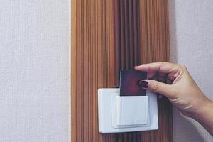 Lady putting key card switch in hotel room photo