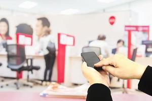 A man is using telephone over colorful blurred bokeh light in office and people background photo