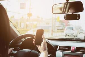 primer plano de un hombre conduciendo un coche peligrosamente mientras usa el teléfono móvil foto