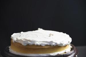 señora haciendo pastel poniendo crema con espátula - concepto de cocina de panadería casera foto