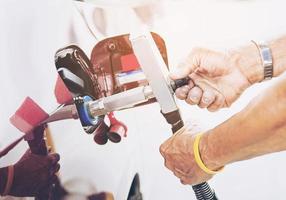 Vintage style photo of man is putting NGV, Natural Gas Vehicle, head dispenser to a car at the gasoline station in Thailand