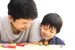 Father is playing Halloween clay with his son over white background photo
