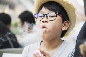 Asian boy eating smoking canny happily - people and snack happy time concept photo