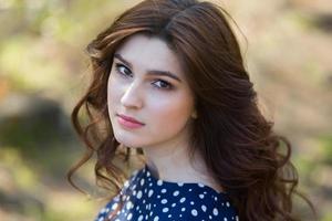 beautiful white european girl with clean skin in the park with flowering trees photo