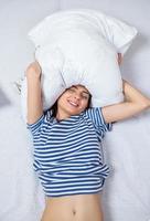 Girl sleeps in a white bed at home. Young woman sleeping in sleepwear on the white linen in bed at home, top view. photo