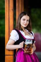 Sexy russian woman in Bavarian dress holding beer mugs. photo