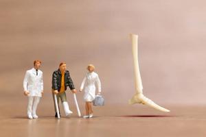 Miniature people Leg injuries patients are discussed  by an orthopedic physician. photo