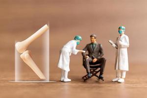 Miniature people patients are discussed  by an orthopedic physician photo