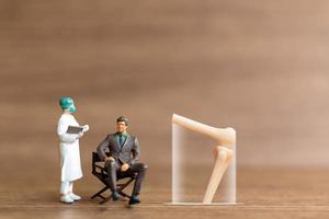 Miniature people patients are discussed  by an orthopedic physician photo