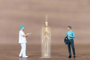 Miniature people patients are discussed  by an orthopedic physician photo